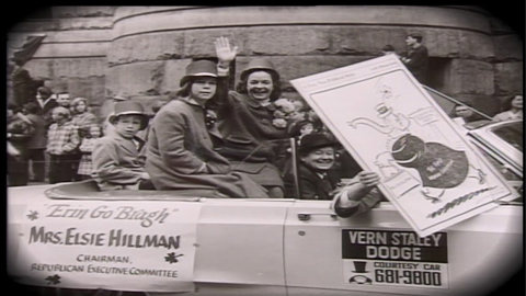 Elsie Hillman waving and riding in a car in a parade