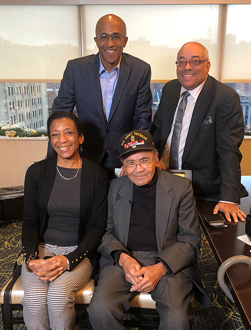 World War 2 Veteran Eugene Boyer Jr. and his son, Eugene Boyer III, pose with Chris Moore and producer Minette Seate during their interview.