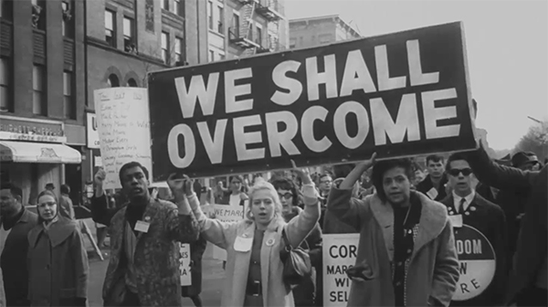 Old photo of sign that reads We shall overcome