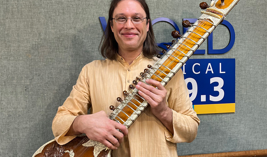 Michael Griska in WQED-FM Studios holding his sitar