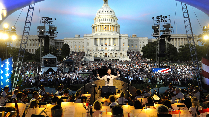 Jack Everly conducts the National Symphony Orchestra before the on-site audience on the West Lawn of the U.S. Capitol.
